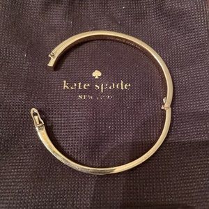 kate Spade thin bracelets. One all gold; the other with whit enamel.